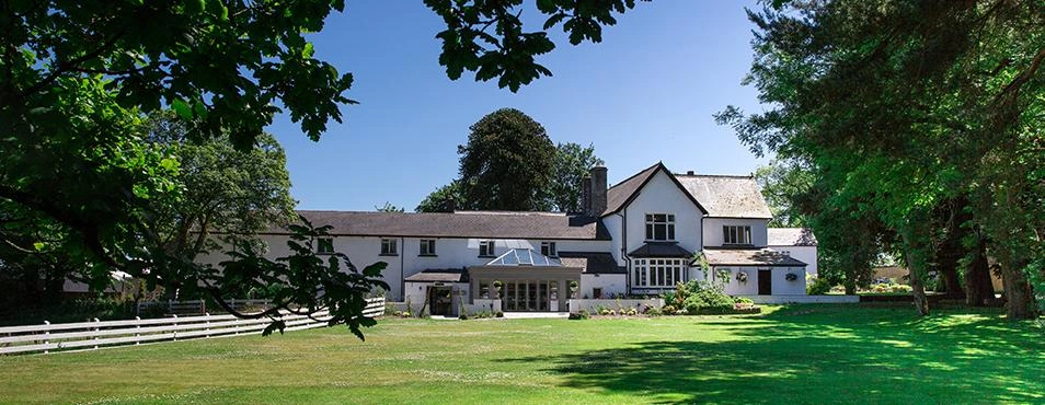 Llechwen Hall country house framed by trees and lawns