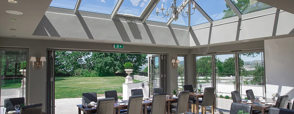 The orangery restaurant, glass roof and bi-fold doors open onto the lawn